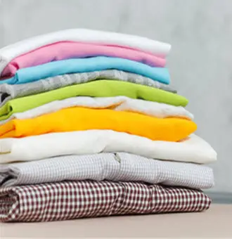 Freshly washed and neatly folded colorful clothes from Pressed & Fresh laundry service.