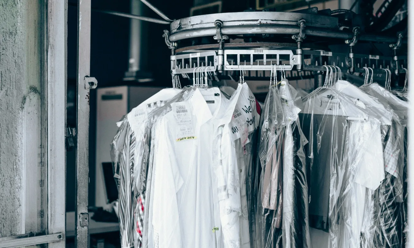 Professionally dry cleaned suits and coats hanging on a rack